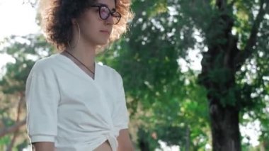 Hippi ve moda genç bayan parkta kaykayla poz veriyor.