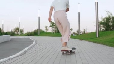 Hippi ve moda genç bayan parkta kaykaya biniyor.