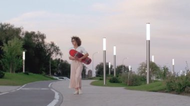 Kadın parkta paten kayıyor.