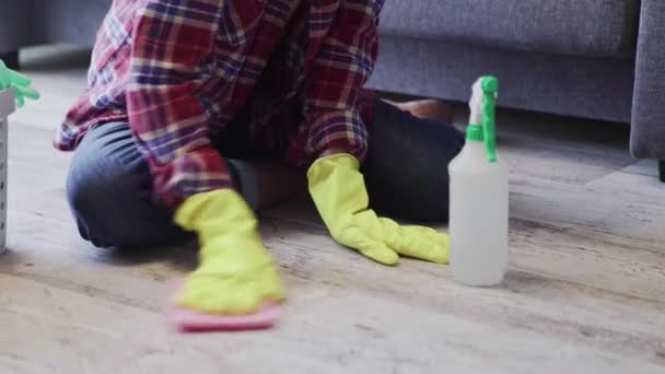 Onherkenbare vrouw die de vloer van de woonkamer schoonmaakt — Stockvideo