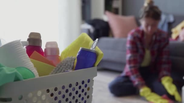 Mand vol sponzen en huishoudelijke chemicaliën met vrouw op wazige achtergrond — Stockvideo