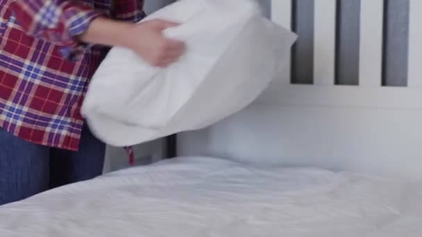 Mulher limpando sua cama no quarto, bela fêmea configurar e fazer cama, organizando suas almofadas e almofadas ordenadamente — Vídeo de Stock
