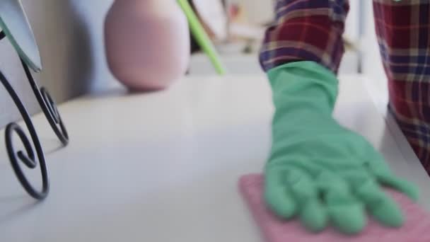 Mujer joven usando una esponja rosa para quitar el polvo de la mesa — Vídeos de Stock