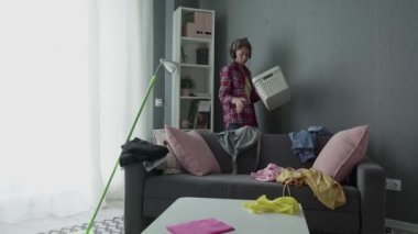 Kadın sepetten dağınık eşyaları topluyor.