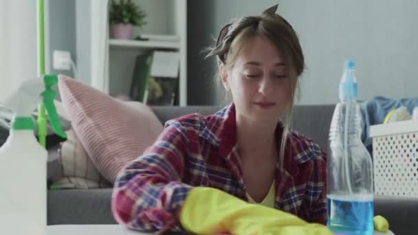 Mujer joven usando una esponja rosa para quitar el polvo de la mesa — Vídeos de Stock