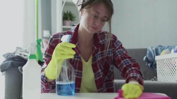 Mujer cansada usando una esponja rosa para tratar de eliminar el polvo de la mesa — Vídeo de stock