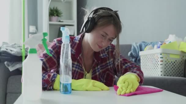 Femme fatiguée utilisant une éponge rose pour essayer dur enlever la poussière de la table — Video