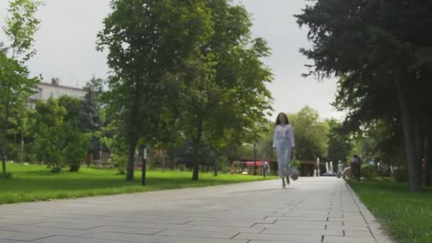 女人拿着装有蔬菜的棉网购物袋在夏季公园里散步。零废物采购. — 图库视频影像