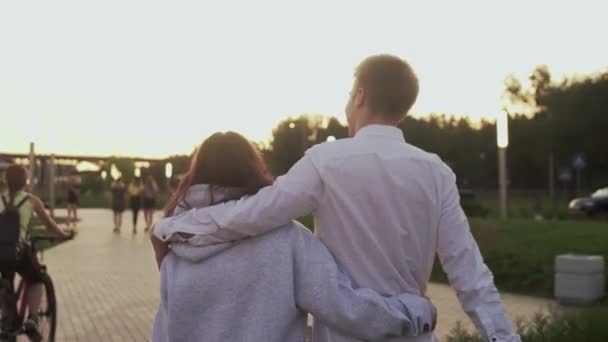 Blick zurück auf junges schönes Paar Dates im Sommerpark am Abend — Stockvideo