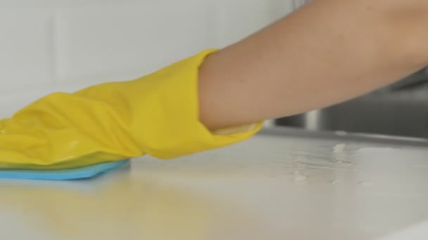 Ama de casa mujer en guantes amarillos limpiar la mesa con trapo azul — Vídeo de stock