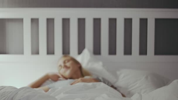 健康的睡眠后，年轻美丽的快乐女人醒来，舒舒服服地躺在舒适的床上 — 图库视频影像