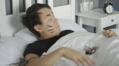 Baş ağrısı olan sarhoş bir adam gece partisinden sonra uyanır, odayı dağıtır, akşamdan kalma olur.