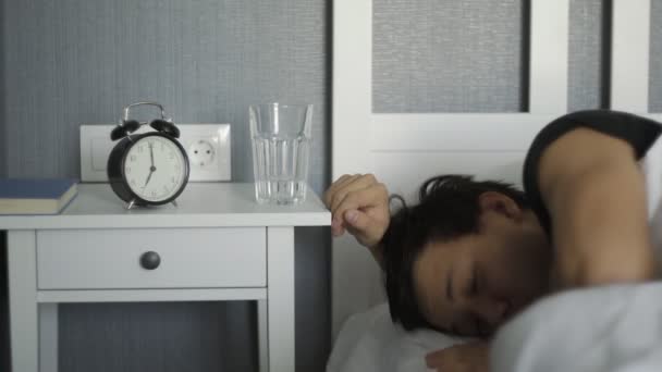 Жаждущий мужчина просыпается и пьет воду в постели дома — стоковое видео