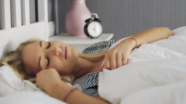 Mulher acordando e se alongando na cama branca no quarto — Vídeo de Stock