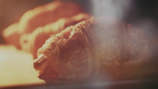 Cerca de deliciosos y frescos croissants están en la bandeja en el horno — Vídeos de Stock