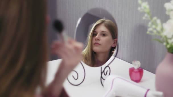 Mladá žena pomocí pudru štětcem tvoří přední zrcadlo. — Stock video
