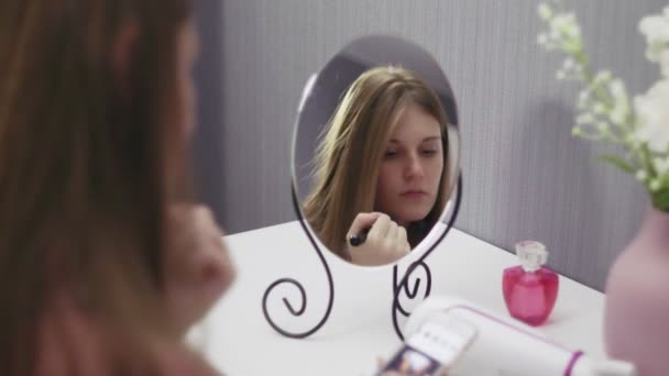 Jovem bela mulher segurando escova aplicar pó blush e usando smartphone — Vídeo de Stock