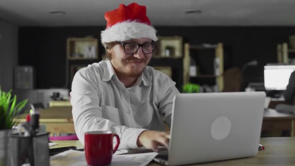 Gerente de bom humor trabalhando no computador portátil no escritório no Natal — Vídeo de Stock