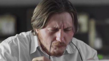 Gözlüklü müdür ofiste dizüstü bilgisayarda çalışıyor.