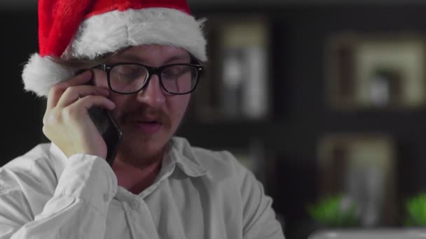ビジネスマンはクリスマスにオフィスでスマートフォンで話しています — ストック動画