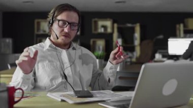 Kulaklıklı müdür ofiste masa başında çalışıyor.