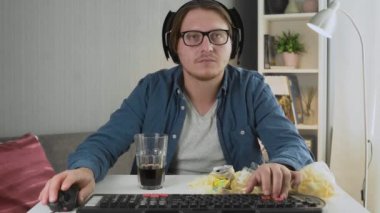 Bilgisayarında video oyunu oynayan genç adam.