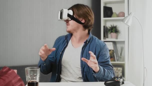 집에서 현대 가상 현실 안경을 쓰고 있는 젊은이 — 비디오