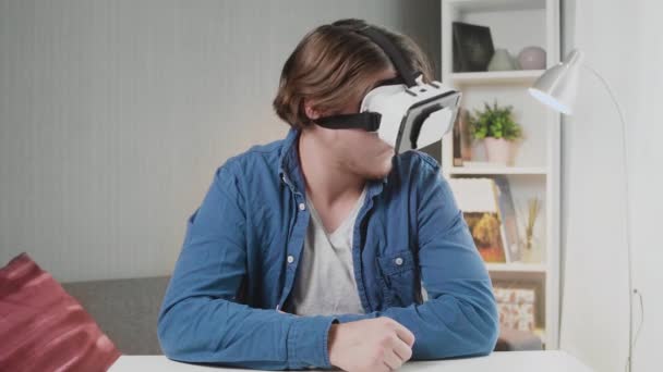 Молодий чоловік в окулярах віртуальної реальності в кімнаті — стокове відео