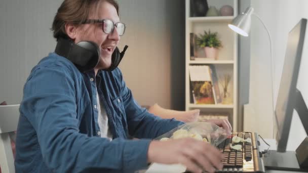 Vista laterale del giovane che gioca al videogioco a casa sentendosi felice dopo il vincitore e mostrando gesto indecente — Video Stock