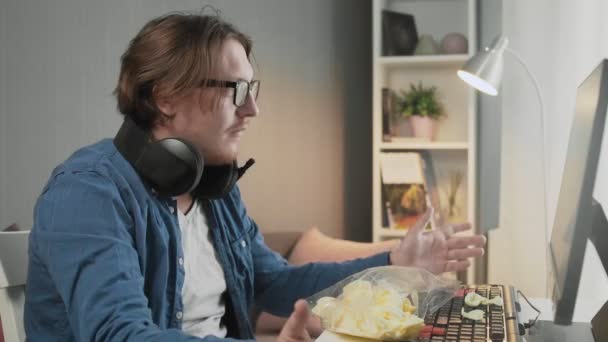 Funny young man in headset with pc computer playing game at home. — Stock Video