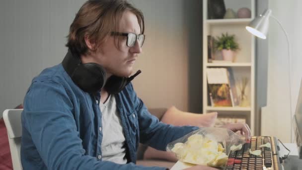 Side view of concentrated young man playing video game and sitting in front of monitor — Stock Video