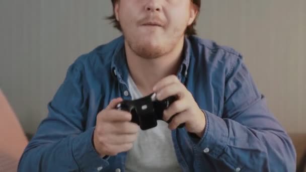 Detailní záběr mladého muže hraje videohry a na pohovce večer — Stock video