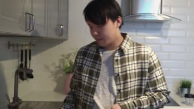 Genç hasta Asyalı mutfakta Türk kahvesi içiyor.