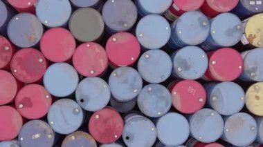 Bir sürü eski kirli petrol varillerinin üzerinden uçarak.