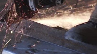 Adam dairesel testere ile çalışıyor. Sıcak metalin kıvılcımları.