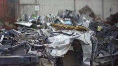 Mekanik kollu bir makine, şehir çöplüğünden eski bir arabayı alıyor..