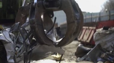 Mekanik kollu makine eski arabayı yakalıyor.