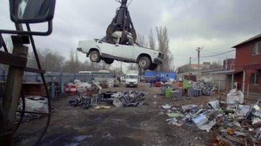 Mekanik kollu makine eski arabayı yakalıyor.