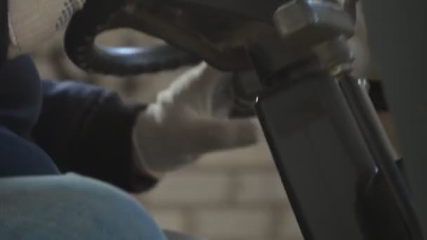 Работник в форме поворачивает руль в кабине погрузчика вилочного погрузчика экстремально близко . — стоковое видео
