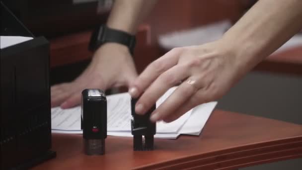 Close up of female hand that puts a stamp in the contract or documents. — Stock Video