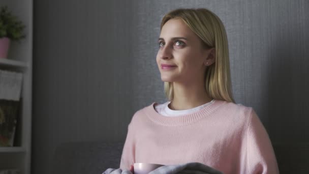 Close up of young woman sits on gray couch and drinks a tea — Stock Video