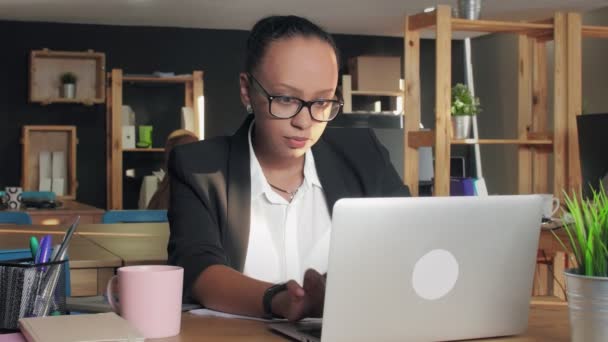 Mujer afroamericana insatisfecha en tipos de gafas en notebook y luego lo cierra — Vídeo de stock