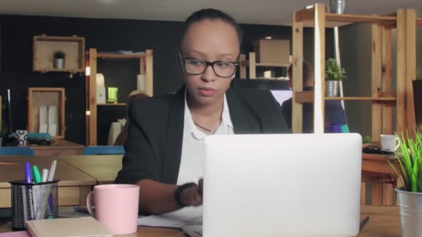 Young african american woman typing on laptop and drinking a coffee — Stock Video