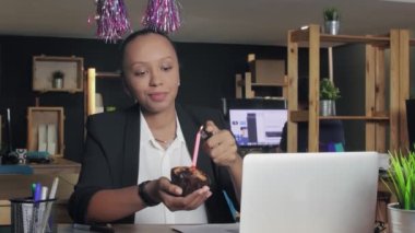 Üzgün Afrikalı Amerikalı kadın müdür ofiste doğum gününü kutluyor.