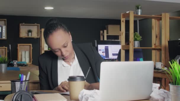 Mladý africký Američan žena dělá poznámku na notebook v koworking kancelář — Stock video