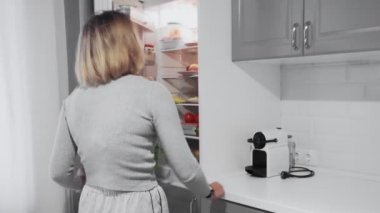 Kadının buzdolabını açtığı ve diyeti için en iyi yemeği seçtiği arka plan görüntüsü.