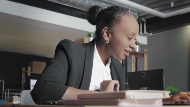 Ευτυχισμένη νεαρή Αφροαμερικανή γυναίκα αισθάνεται επιτυχία και εργάζεται καλύτερα στο γραφείο συνεργασίας — Αρχείο Βίντεο