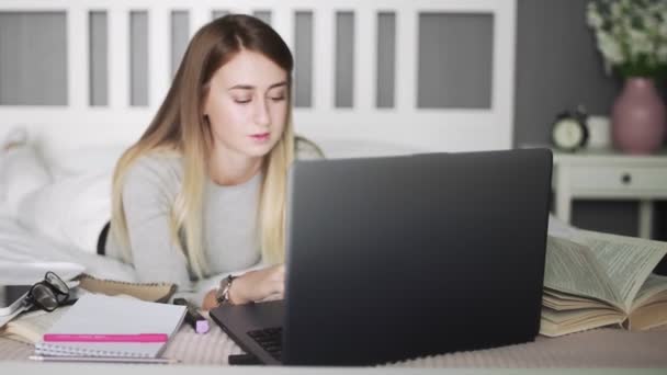 Donna sdraiata sul letto usando il taccuino. Freelance, lavoro a casa, lavoro fuori ufficio . — Video Stock