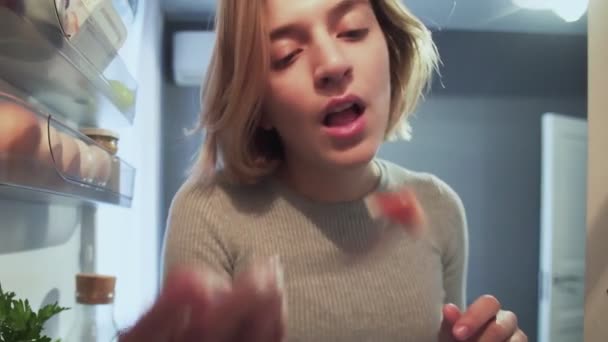 Pohled ven zevnitř lednice jako žena s vidličkou otevírá dveře jí salát a něco jiného — Stock video