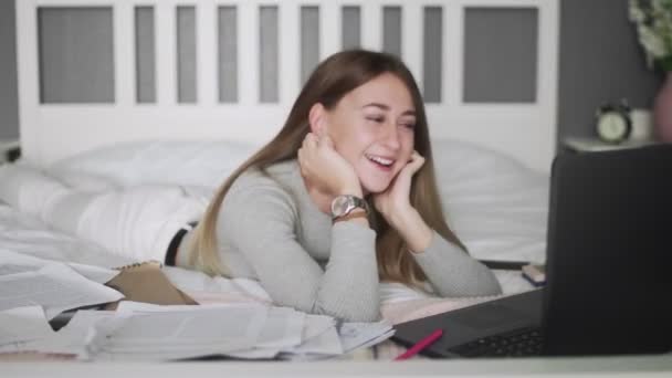 Vrouwelijke freelancer liggend op het bed en bekijk een fanny video in haar timeout — Stockvideo